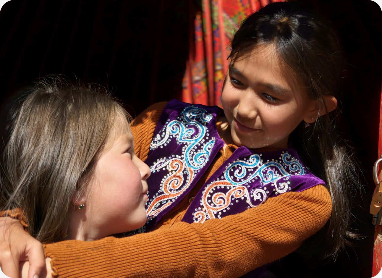 Sharp 3X portrait of hugging girls, showcasing intricate vest details and deep background separation of Find X10 Pro Max