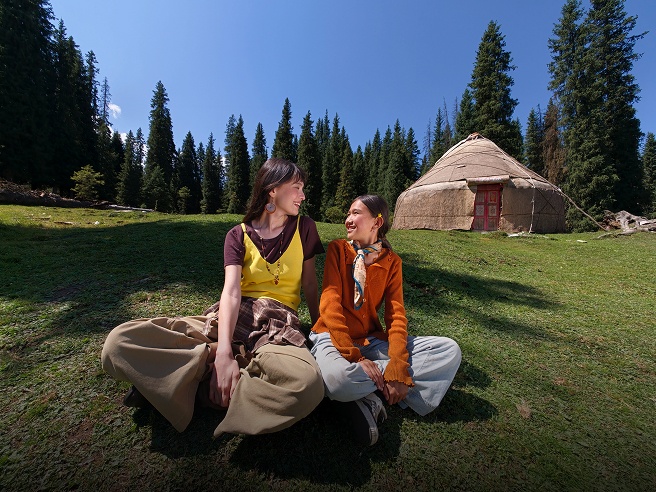 Women with detailed clothing in a landscape with a yurt, showcasing the fine detail capability of Find X10 Pro Max