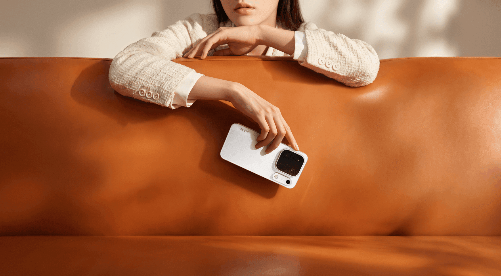Hand holds OPPO Find X10 Pro Max (Luna White) against orange leather, highlighting its refined finish