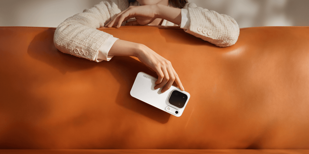 Hand holds OPPO Find X10 Pro Max against orange leather, highlighting its refined finish