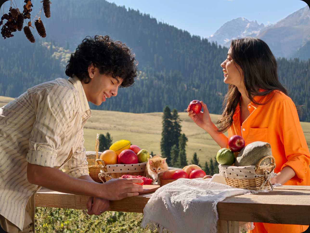 Couple with fresh fruit and a kitten in a mountain picnic scene, showcasing fine detail