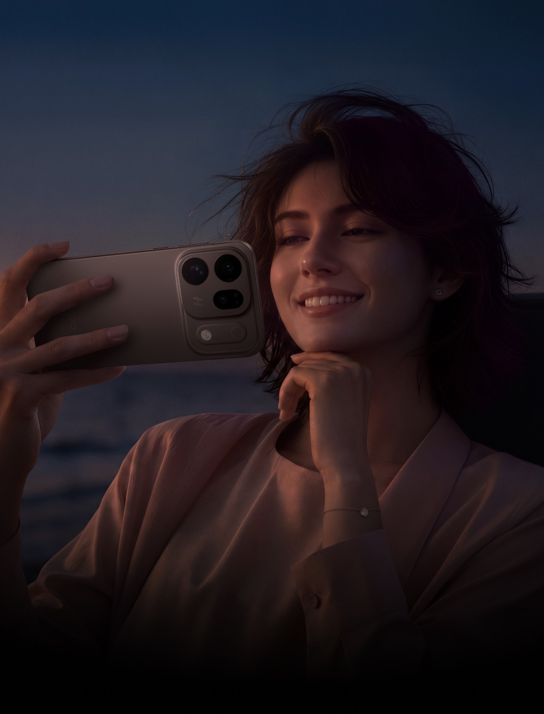 امرأة مبتسمة تحمل هاتف OPPO Find X10 بجانب البحر عند الغسق