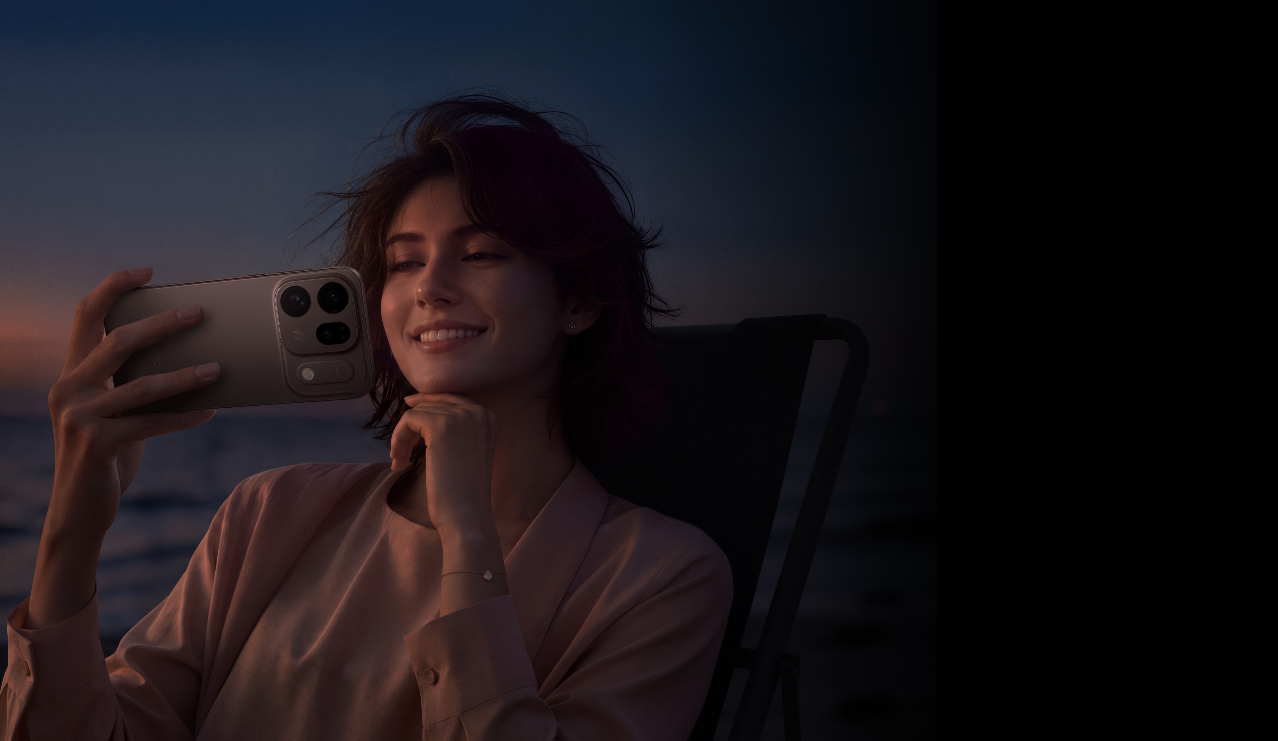 امرأة مبتسمة تحمل هاتف OPPO Find X10 بجانب البحر عند الغسق