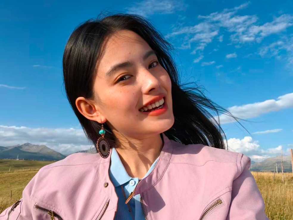 صورة سيلفي مشرقة في الهواء الطلق لامرأة مبتسمة، التُقطت بكاميرا 50MP Luminous Selfie Camera