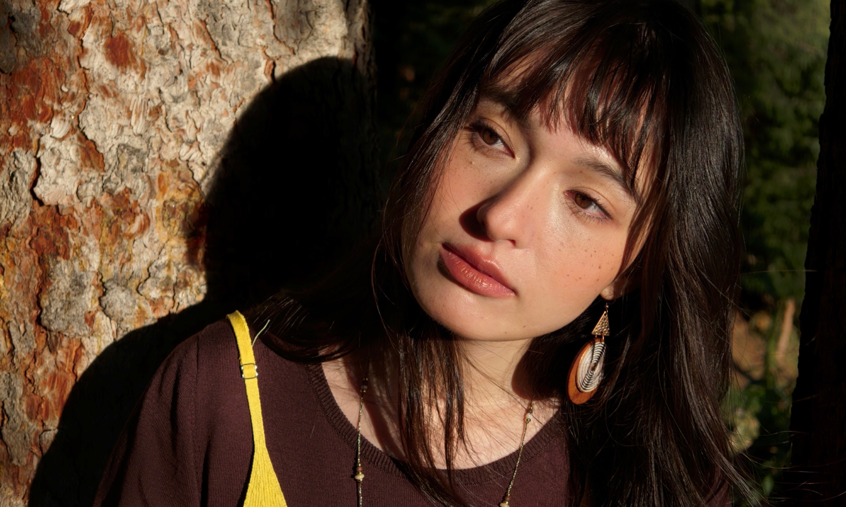 Portret kobiety opierającej się o drzewo, ukazujący działanie silnika LUMO Natural Tone w Find X10