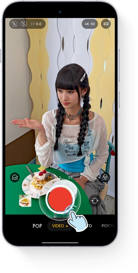 A smartphone screen displaying a video recording interface with a cartoon hand clicking the red shutter button